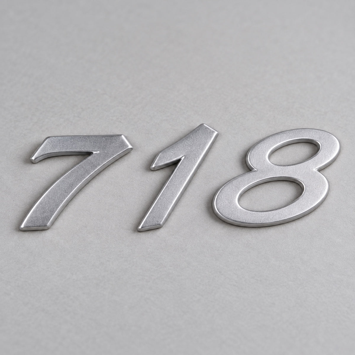 Silver-coloured aftermarket 718 badge set