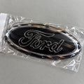 Black and chrome-effect aftermarket Ford oval badge in packaging