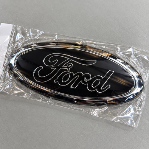Black and chrome-effect aftermarket Ford oval badge in packaging