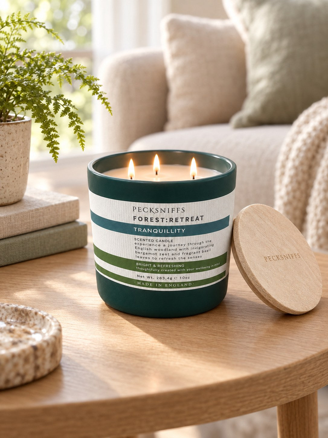 Tranquillity 3-wick candle lit on a living-room side table (styled image)