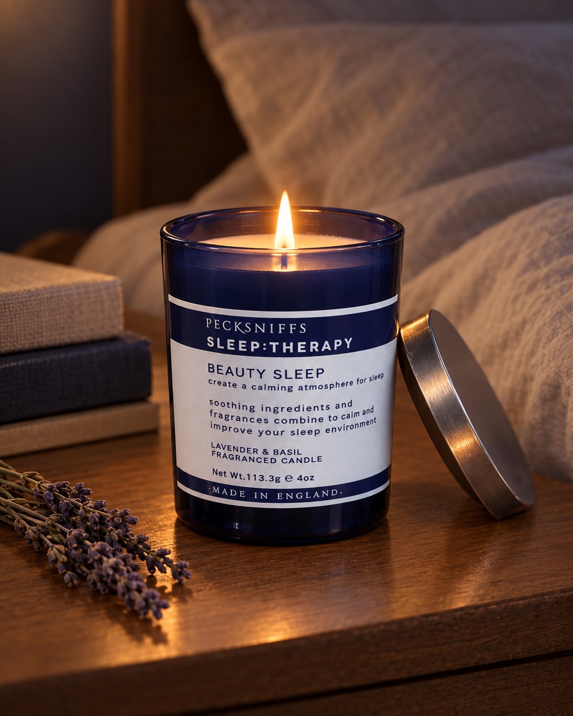 Beauty Sleep candle lit on a bedside table (styled image)