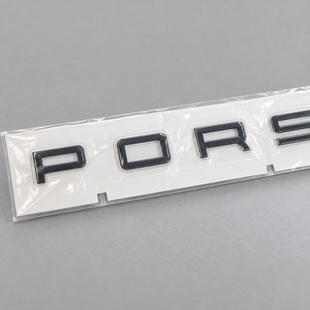 Black aftermarket Porsche seven-letter badge set in packaging